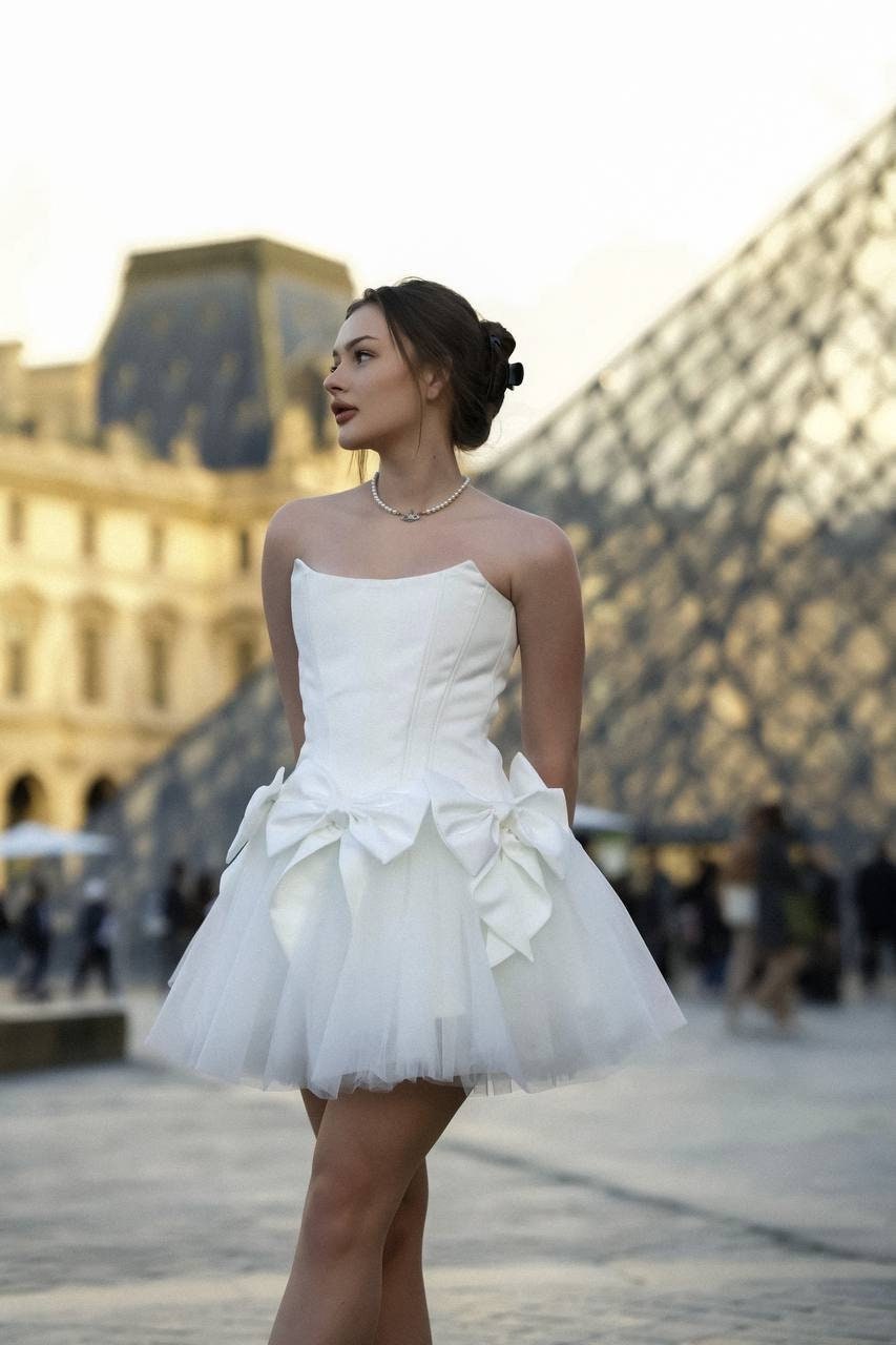 Romantic ivory corset dress with flowing tulle skirt and delicate bows accents - timeless beauty. Perfect for weddings or special occasions.